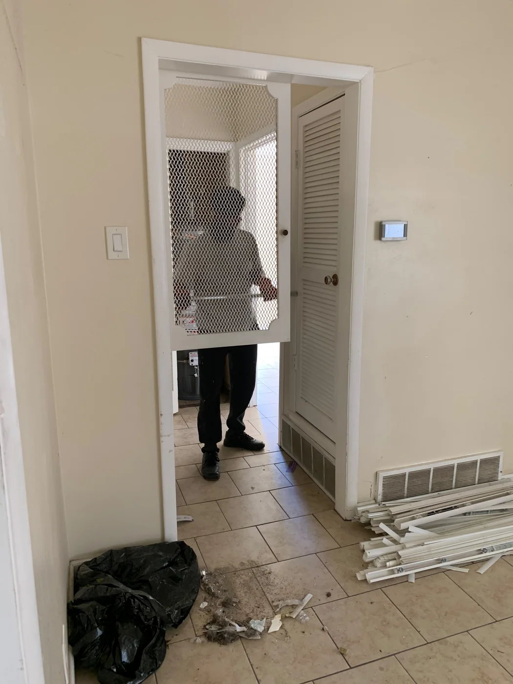 Dad at a residential work site with removed trim and debris awaiting cleanup, work in progress